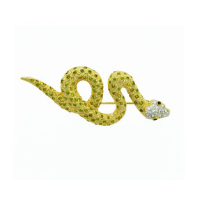 SWEET SNAKE - SWEET SNAKE è una spilla raffigurante un dolce ed elegante serpente, un animale che incarna grazia, seduzione e mistero. 
Questo accessorio è realizzato in oro chiaro con strass cristallo, olivine e occhi neri. - A.Z. Bigiotterie